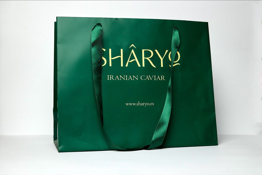 Green bag with ribbon handles and foil stamping